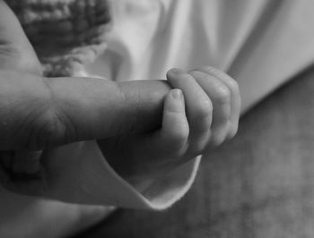 Close-up of baby hand holding finger