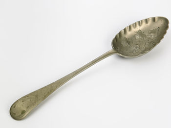 Close-up of old spoon over white background