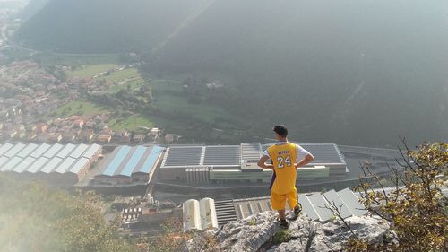 High angle view of man in sports clothing overlooking village