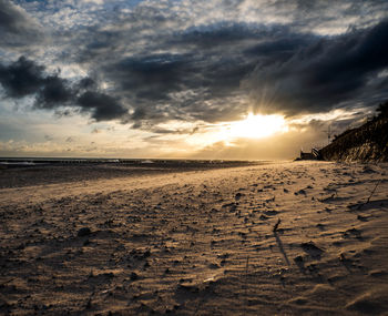 Surface level of beach against sky during sunset