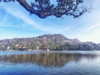 Scenic view of lake by mountains against sky