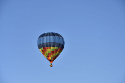 Low angle view of hot air balloon against clear blue sky