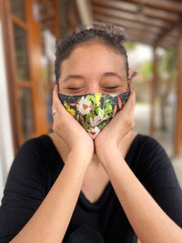 Close-up of woman wearing mask sitting outdoors