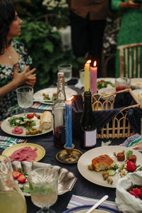Food and drinks with illuminated candles at table during party
