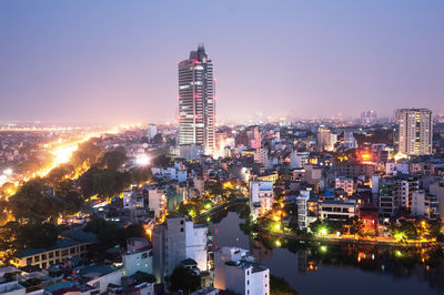 Illuminated buildings in city against sky at night