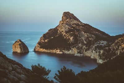 Scenic view of rocks in sea against sky