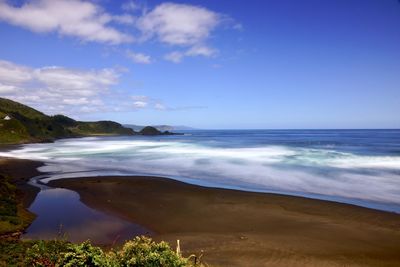 Scenic view of sea against blue sky