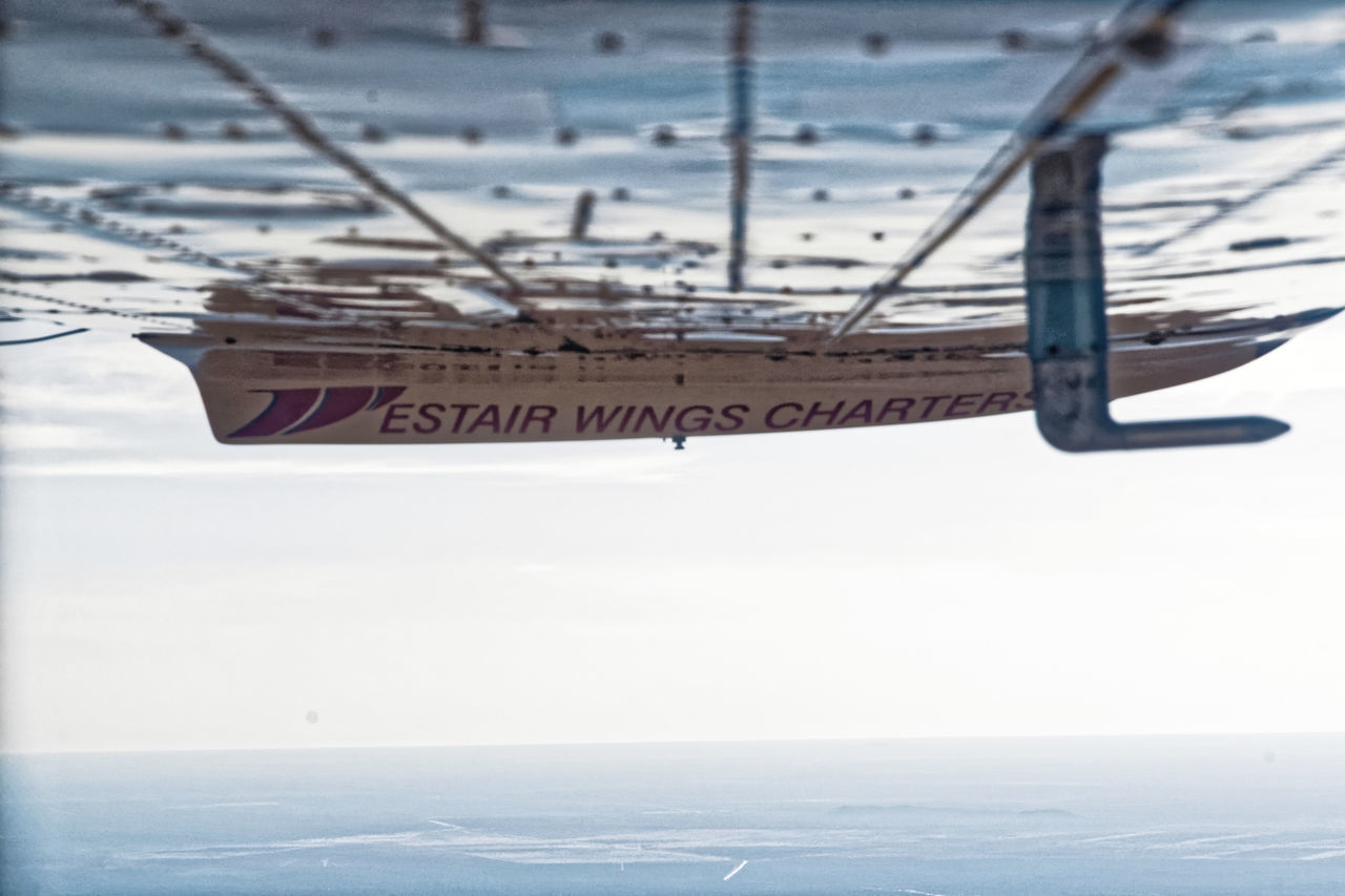 CLOSE-UP OF AIRPLANE AT AIRPORT AGAINST SKY