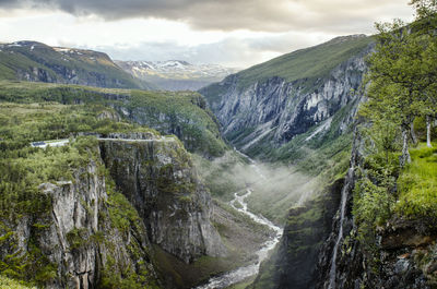 Scenic view of river amidst mountains against sky