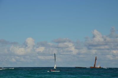 Sailboat sailing on sea against sky