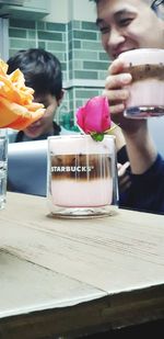 Close-up of man holding ice cream in glass on table