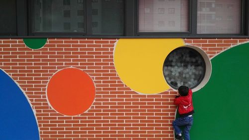 Full length of boy standing in front of wall