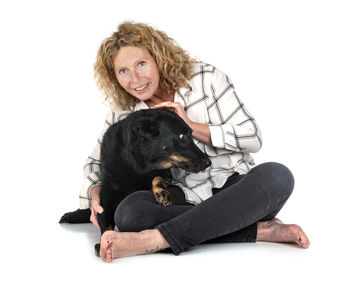 Portrait of woman with dog against white background