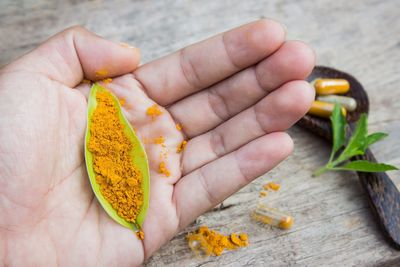 High angle view of turmeric in leaf on palm of hand