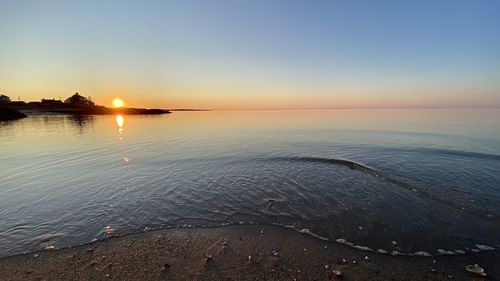 Scenic view of sea against clear sky at sunset