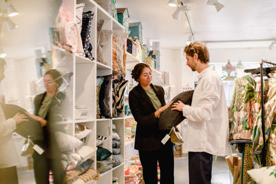 Man and woman looking at cushion in retail store