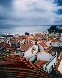 High angle view of townscape by sea against sky