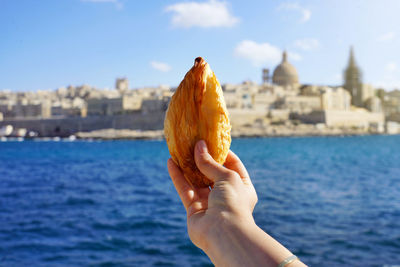 Traditional savoury pastry pastizzi from malta with valletta old town on background, malta island