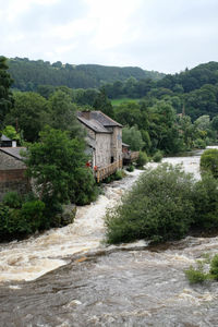 High angle view of river flowing by houses against mountains