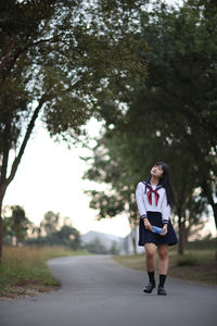 Full length of woman standing on road