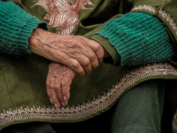 Midsection of senior woman wearing green warm clothing