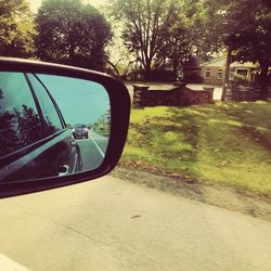 Road seen through side-view mirror of car