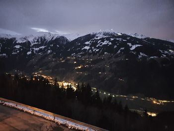 High angle view of illuminated snowcapped mountains against sky at night