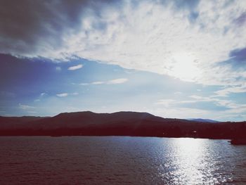 Scenic view of lake by mountains against sky