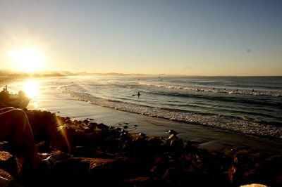 Scenic view of beach against clear sky during sunset