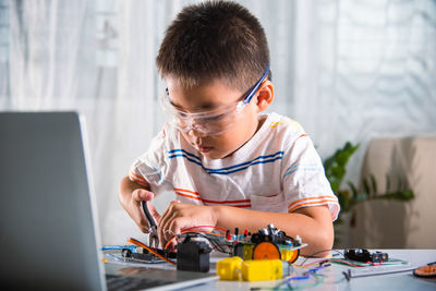 Side view of man using laptop at home