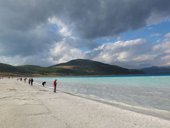 People on beach against sky