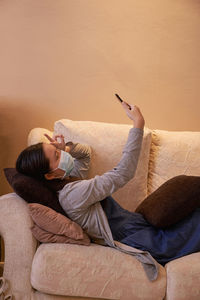 Woman using mobile phone sefie on sofa