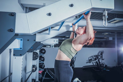 Side view of woman exercising at gym