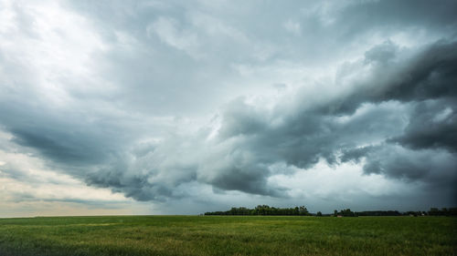 Scenic view of field against cloudy sky