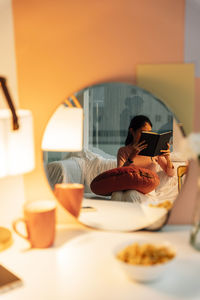 Midsection of woman using mobile phone while sitting on table