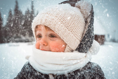 Close-up of boy crying in warm clothing during snowfall