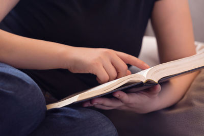 Midsection of woman reading book