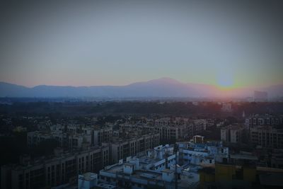 High angle view of buildings in city at sunset