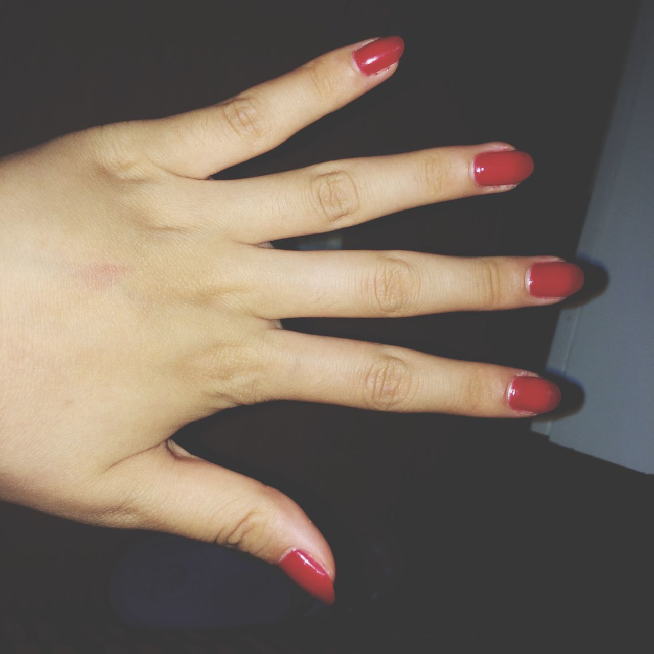 person, part of, indoors, human finger, cropped, holding, close-up, lifestyles, studio shot, red, unrecognizable person, black background, nail polish, femininity, leisure activity, fashion