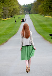 Rear view of woman walking on footpath