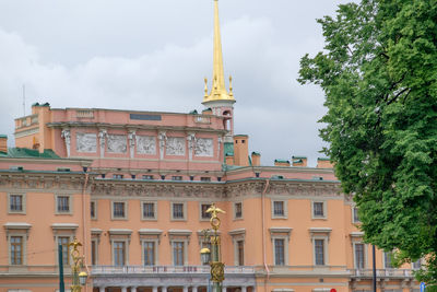 Buildings in city against cloudy sky