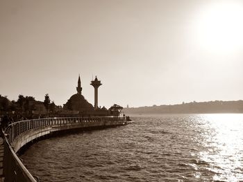 Bridge over river in city against clear sky