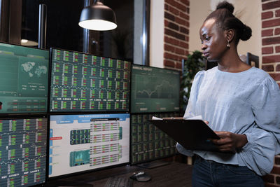 Young businesswoman analyzing graph on computer