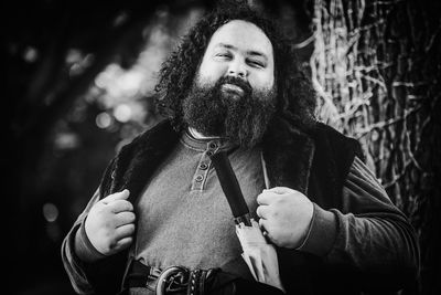 Portrait of smiling man standing against tree