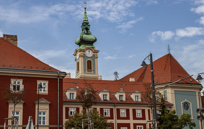 Low angle view of buildings against cloudy sky