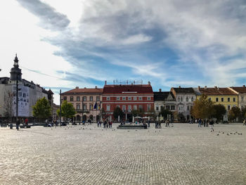 Buildings in town against cloudy sky