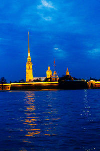 Illuminated built structures against blue sky