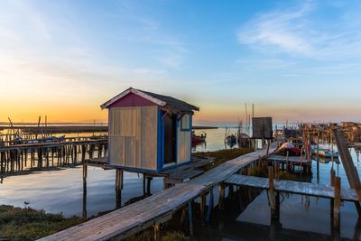 Pier over sea against sky at sunset