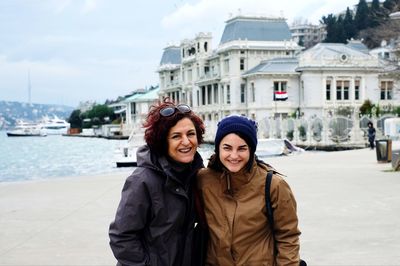 Portrait of smiling woman against building in winter