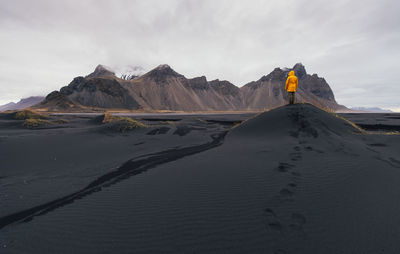 Man standing on black sand in desert